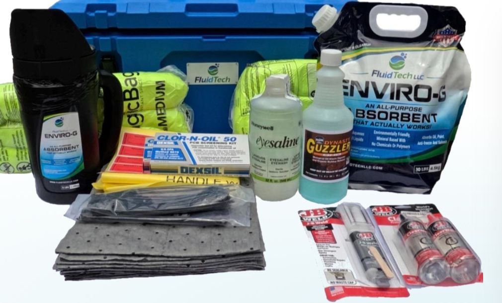 Contents of the FTUTG50 PCB/Oil Kit laid out in front of its blue case: ENVIRO-G absorbent bag and shaker, absorbent socks and pads, Clor-N-Oil 50 PCB screening kit, eyewash, degreaser, and J-B Weld
